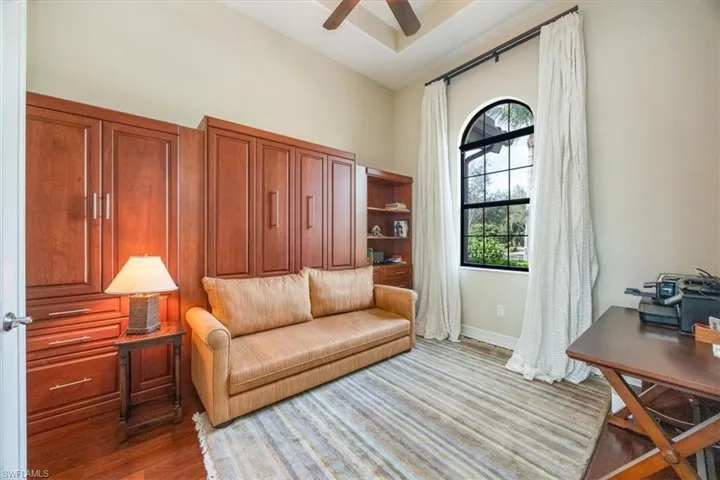Living area with wood finished floors, a high ceiling, and ceiling fan