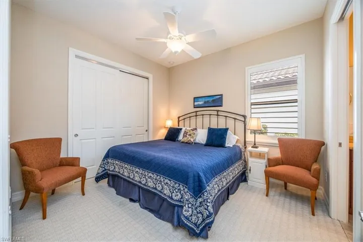 Bedroom with ceiling fan, a closet, and light carpet