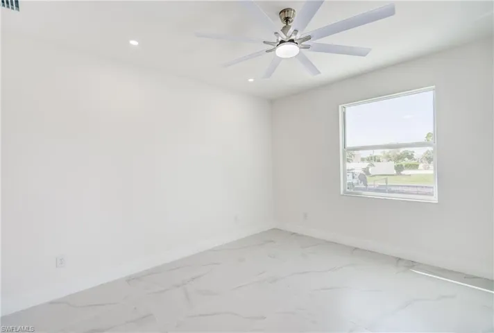 White walls, large window, tile flooring, recessed lighting, and a ceiling fan