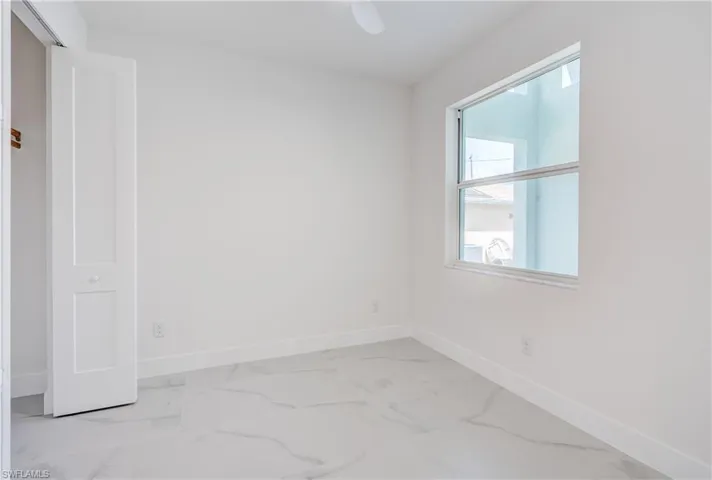 White walls, white trim, and a white ceiling fan