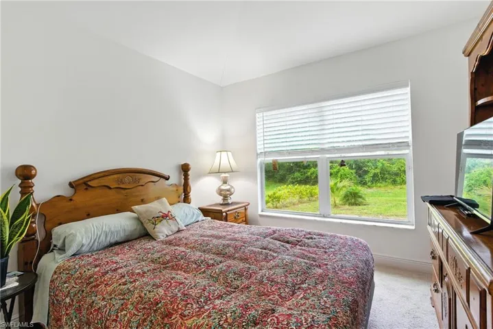 Bedroom with light colored carpet and baseboards