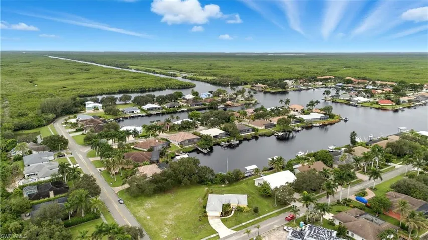 Aerial view of property and surrounding area with a large body of water and nearby suburban area
