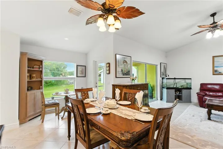 Dining space featuring lofted ceiling, a ceiling fan, and light tile patterned floors