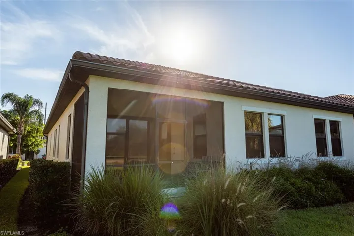 Furnished patio w/ privacy shades overlooking oversized backyard and pond.