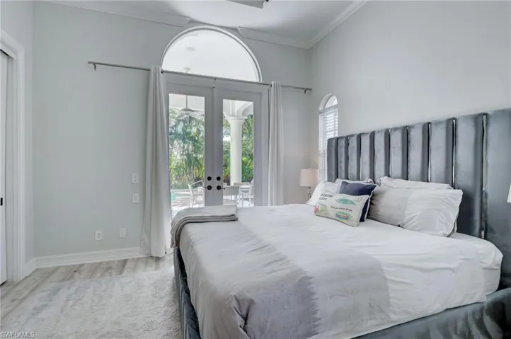Bedroom featuring access to outside, french doors, light hardwood / wood-style floors, and ornamental molding