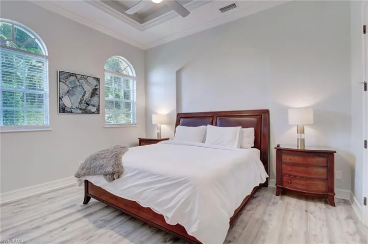 Bedroom with ceiling fan, crown molding, and light hardwood / wood-style floors