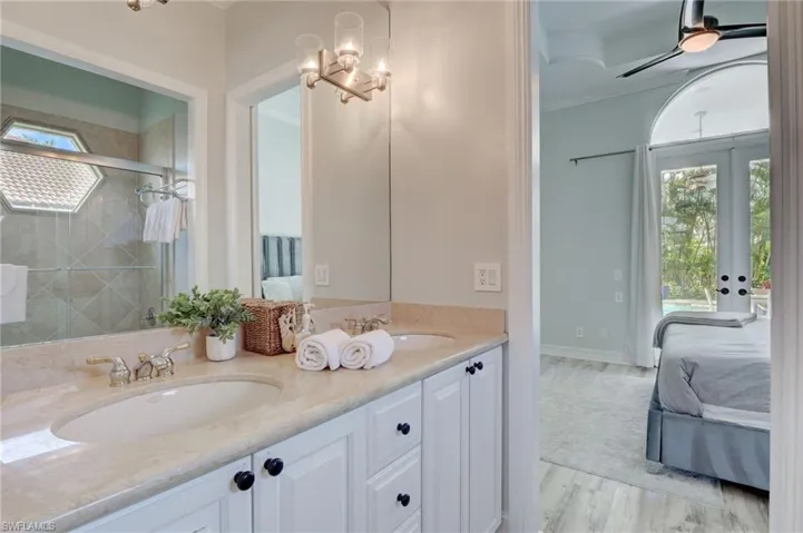 Bathroom with ceiling fan, a wealth of natural light, vanity, and hardwood / wood-style flooring