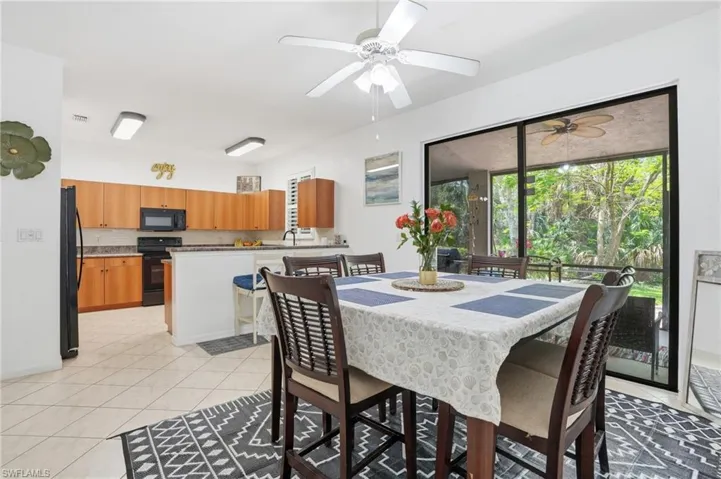 Dining area featuring tile flooring, a ceiling fan, and sliding glass doors to the exterior lanai