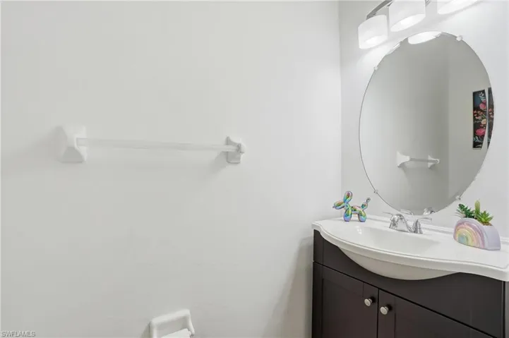 Modern vanity with a dark wood-finish cabinet and an integrated white sink