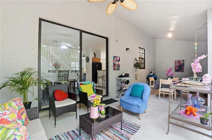 Covered patio featuring a ceiling fan and sconce lighting
