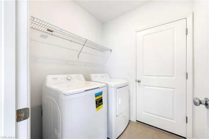 Laundry area with light tile patterned floors and washer and dryer
