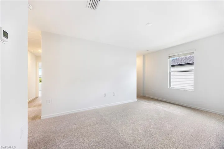 Spare room with light colored carpet and baseboards