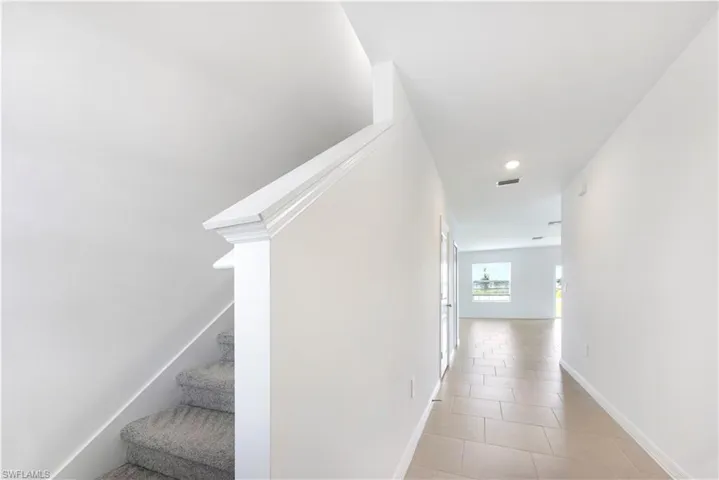 Hallway featuring light tile patterned floors and recessed lighting