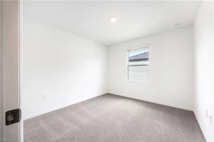 Empty room featuring carpet flooring and baseboards