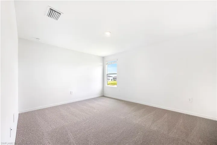 Carpeted empty room featuring baseboards