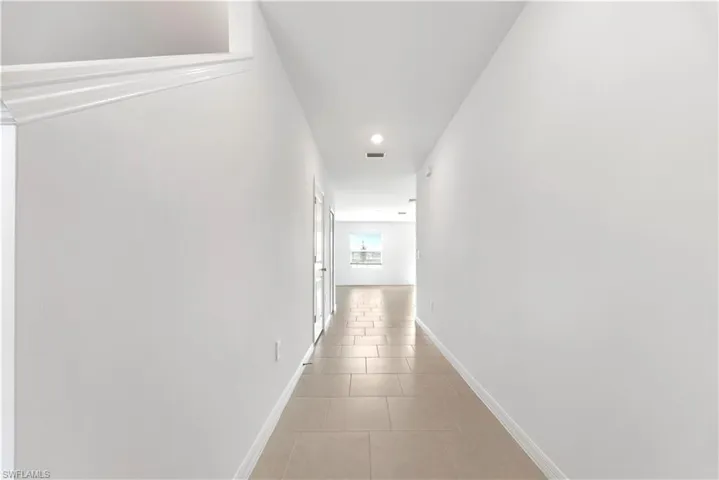 Hall featuring light tile patterned floors and recessed lighting