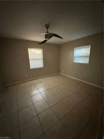 Unfurnished room with ceiling fan and light tile patterned flooring