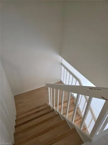 Stairway featuring wood-type flooring and baseboards