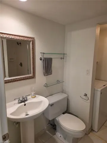 Bathroom with light tile patterned floors and washer / clothes dryer