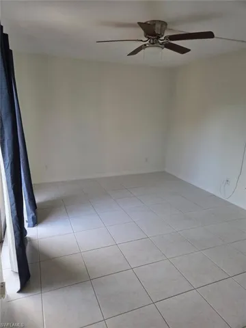 Unfurnished room featuring light tile patterned flooring and ceiling fan
