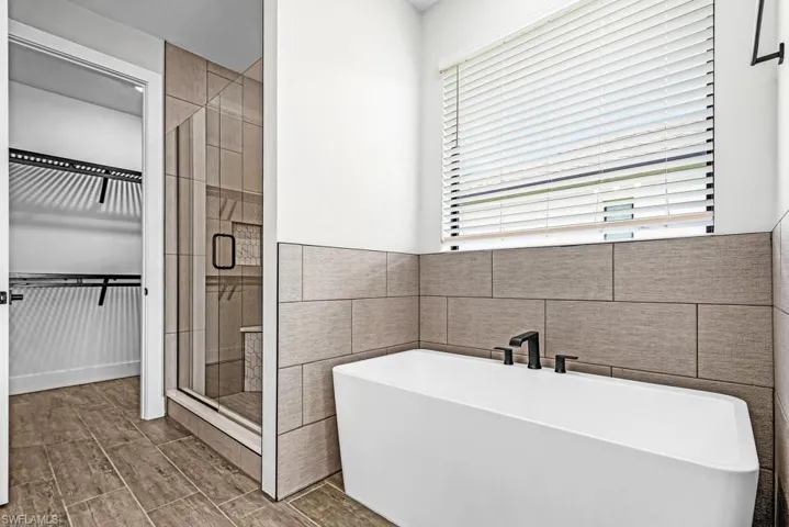 Unfurnished room featuring ornamental molding, wood tiled floors, a tray ceiling, and ceiling fan