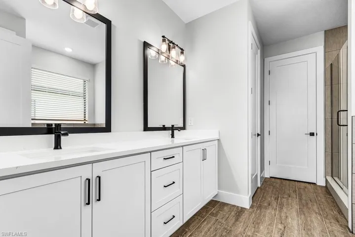 Kitchen featuring white cabinetry, stainless steel appliances, an island with sink, light wood-type flooring, and recessed lighting