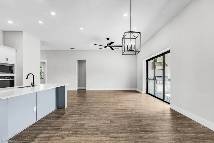 Kitchen featuring dark wood-type flooring, a chandelier, decorative light fixtures, ceiling fan, and recessed lighting