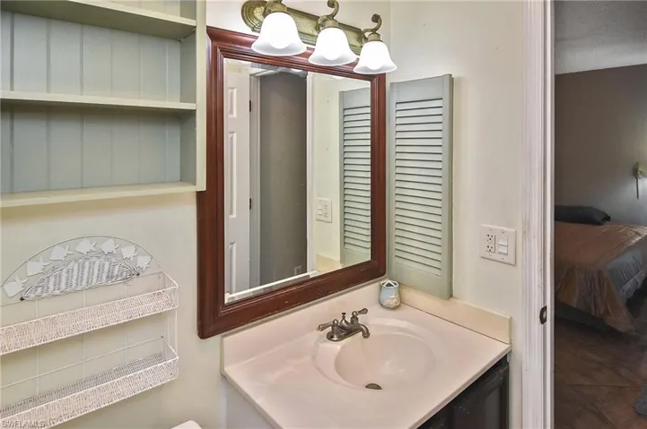 Bathroom featuring vanity, connected bathroom, and dark tile patterned flooring