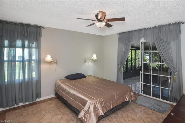 Tiled bedroom with a textured ceiling and ceiling fan