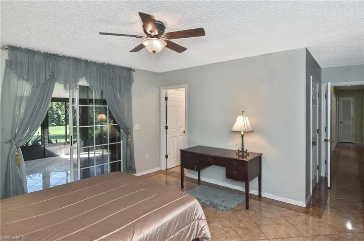 Bedroom with light tile patterned floors, access to outside, a textured ceiling, and ceiling fan