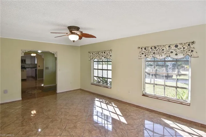 Spare room featuring a textured ceiling, a ceiling fan, and arched walkways