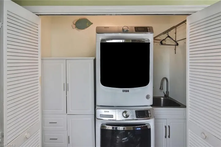 Laundry area with cabinet space and stacked washer / drying machine