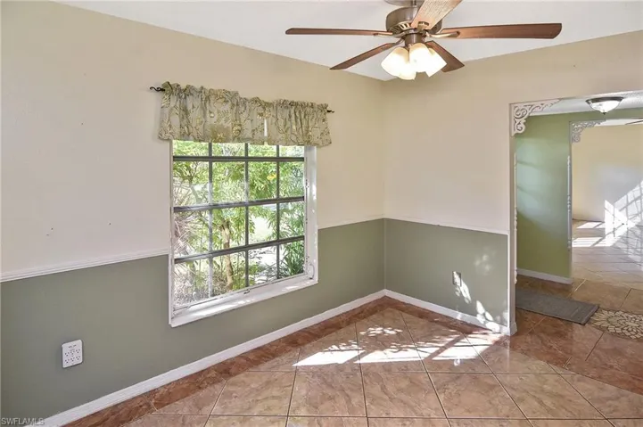Spare room featuring a ceiling fan and tile patterned floors