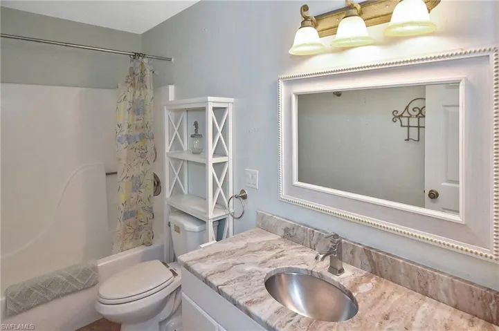 Bathroom with vanity and shower / bath combination with curtain
