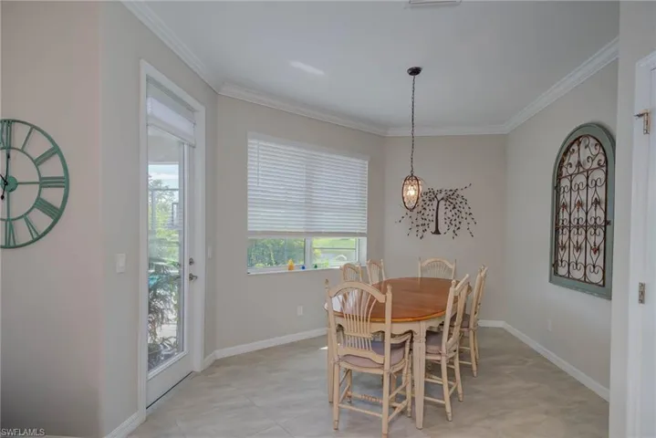 Dining space with crown molding and baseboards