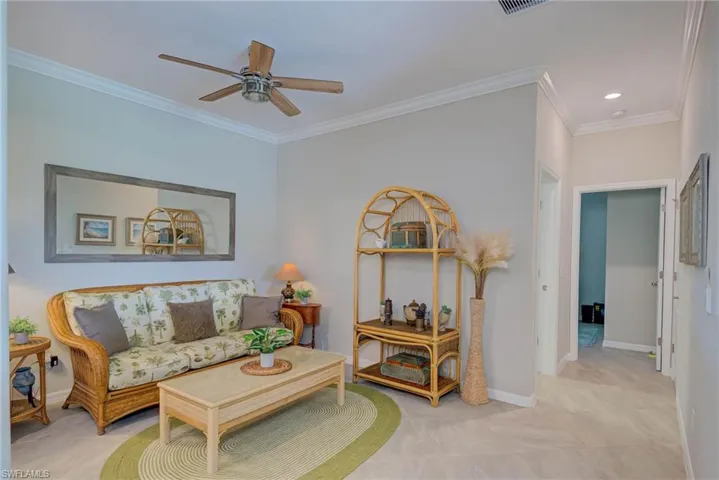 Living area with crown molding and a ceiling fan