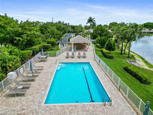 View of swimming pool featuring a water view, a patio area, and a yard