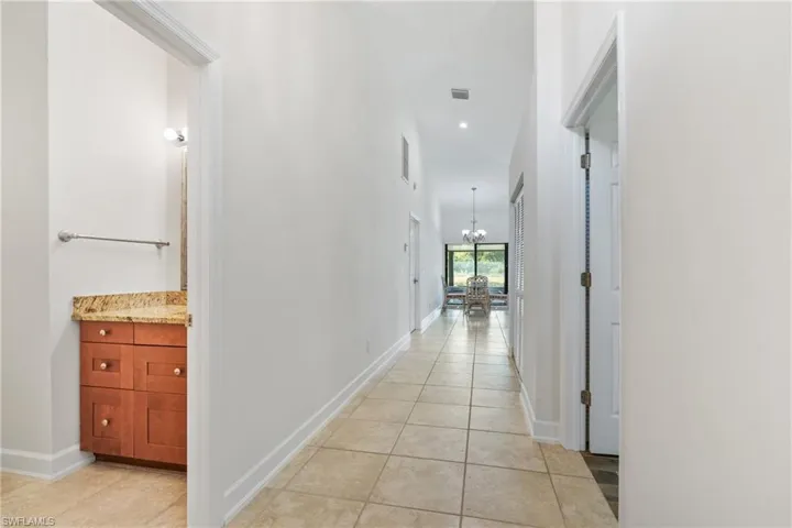 Hall with a chandelier and light tile floors