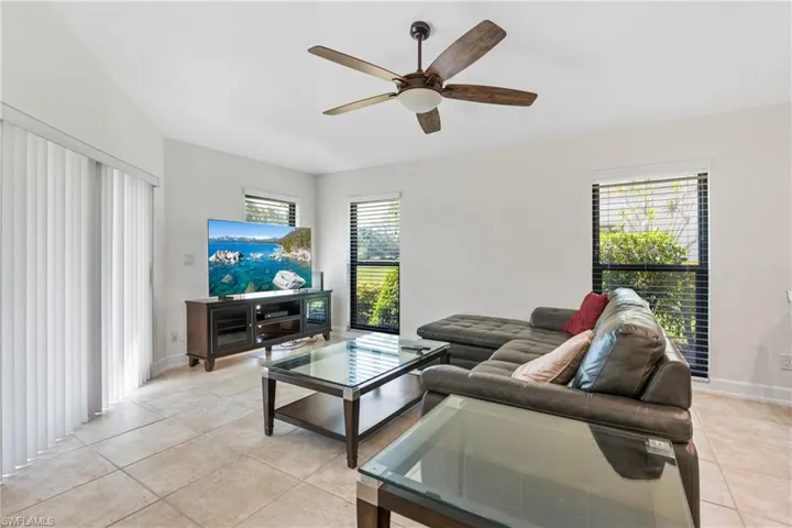 Tiled living room featuring ceiling fan and a healthy amount of sunlight