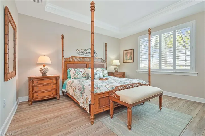 Bedroom featuring ornamental molding, light wood-type flooring, and baseboards