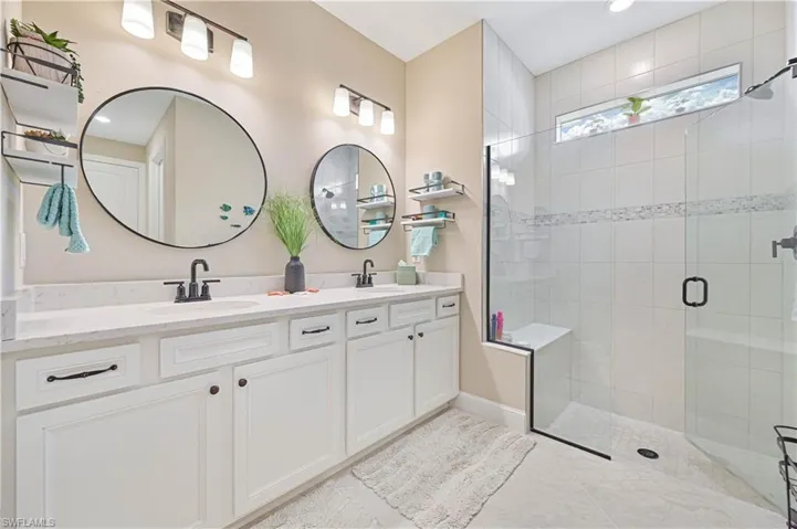 Bathroom with double vanity, a stall shower, recessed lighting, and tile patterned flooring