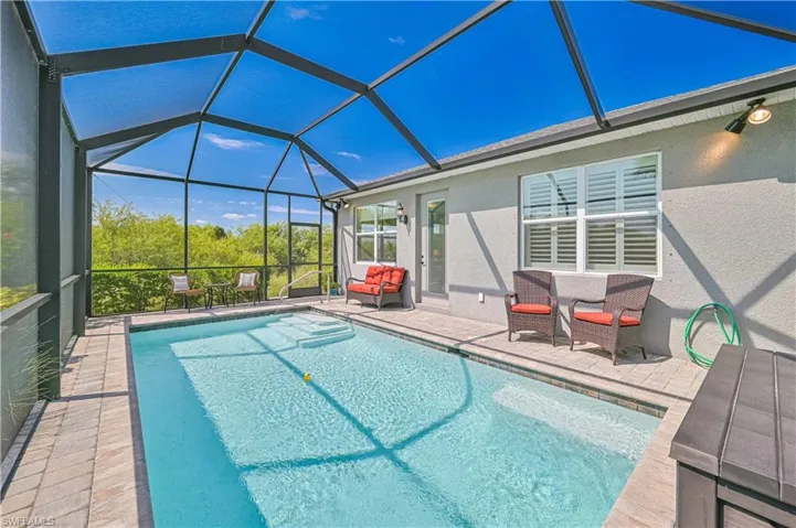 Outdoor pool with a patio and glass enclosure