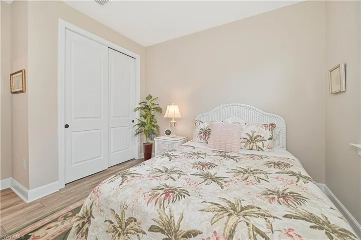 Bedroom with wood finished floors, a closet, and baseboards