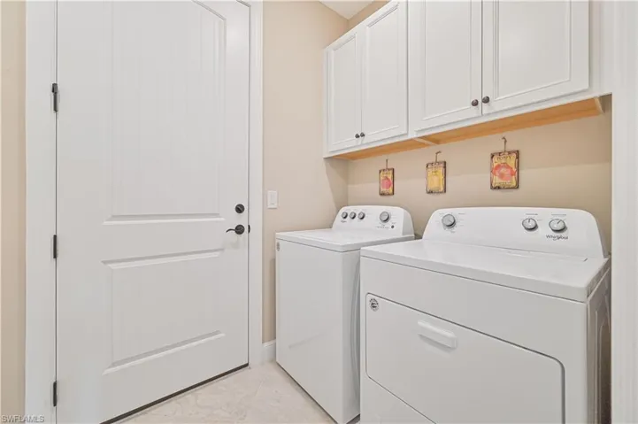Laundry area with separate washer and dryer and cabinet space