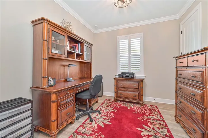 Office area with light wood finished floors, crown molding, and baseboards