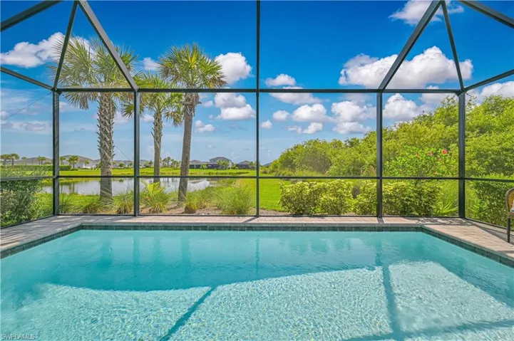 Swimming pool with a lanai and a water view