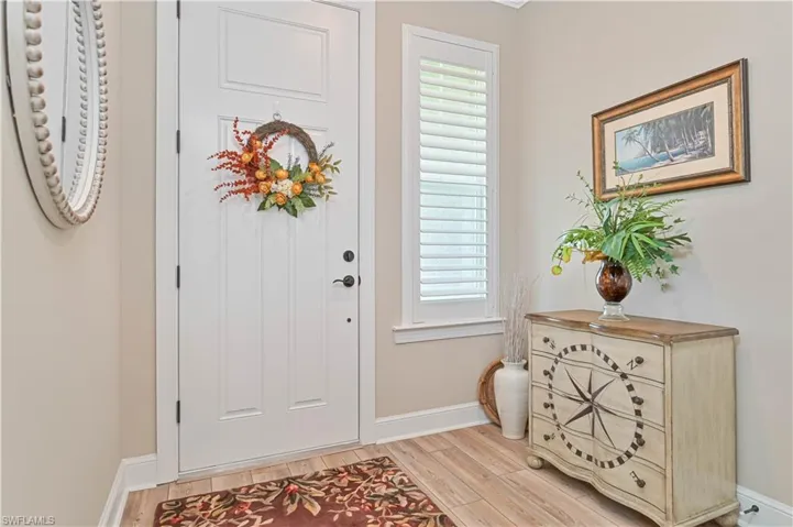 Entryway with baseboards and light wood-style floors