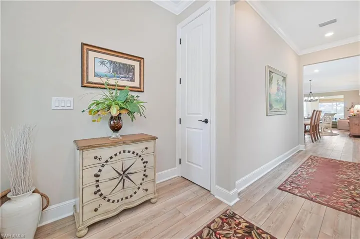 Corridor with crown molding, light wood-style flooring, a chandelier, baseboards, and recessed lighting
