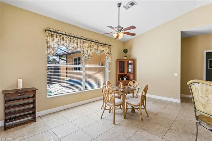 Tiled dining room featuring ceiling fan and lofted ceiling
