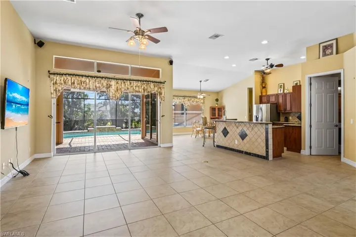 Unfurnished living room with ceiling fan and light tile patterned floors